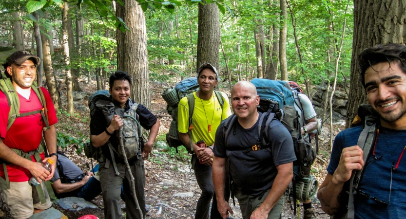 a group of veterans smile at the camera on an outward bound backpacking trip
